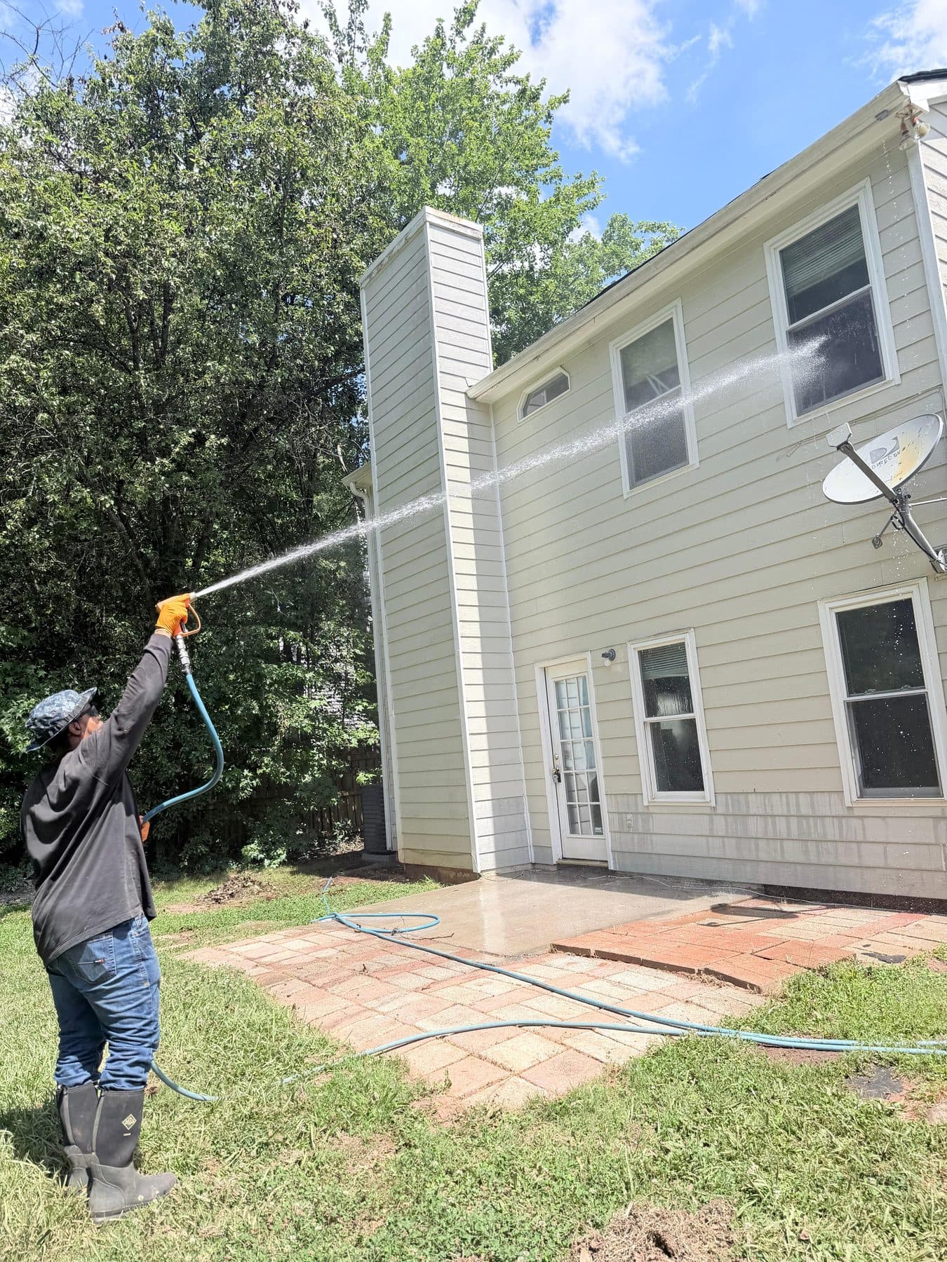 Crew pressure washing a home exterior