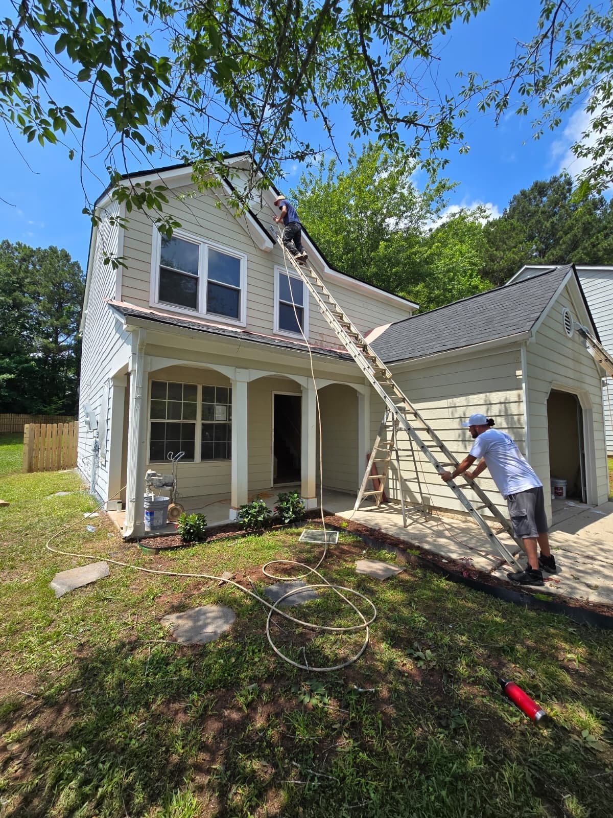 Crew member on a ladder working on the roofline